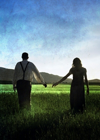 Couple holding hands through a field